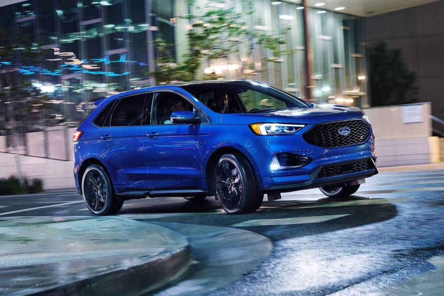 Blue Edge Ford SUV driving around curve at night