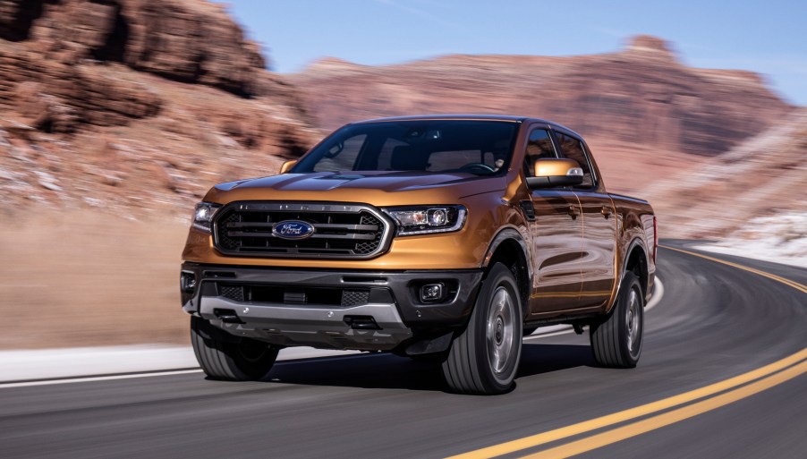 An orange 2019 Ford Ranger at speed on a road with a mountain background