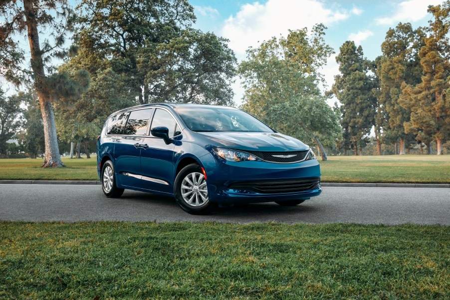 A blue Chrysler Voyager minivan parked on street