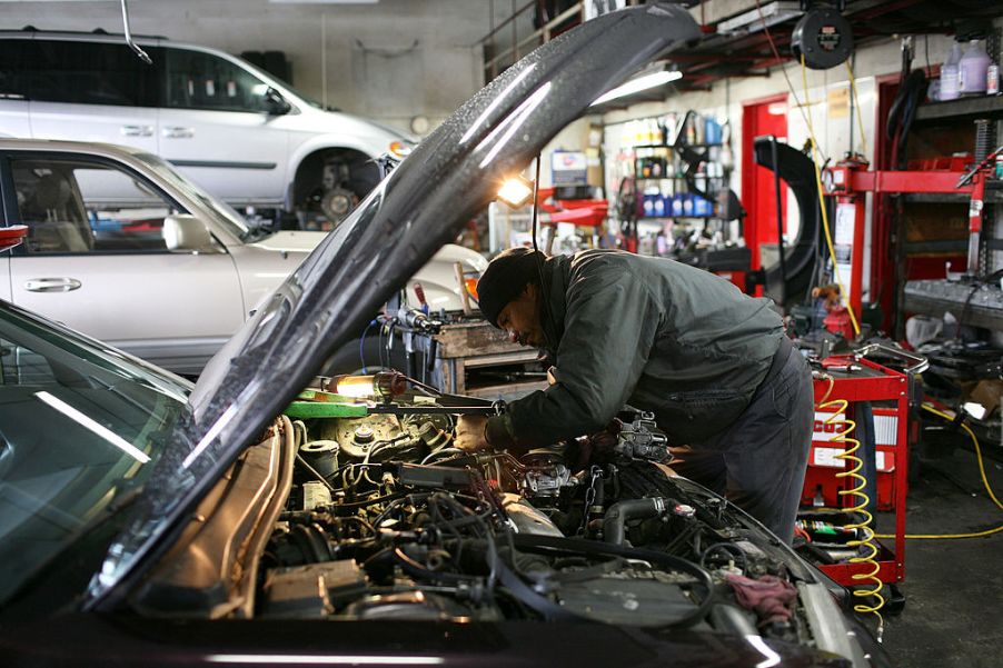 A driver uses an emergency roadside kit to repair his car.