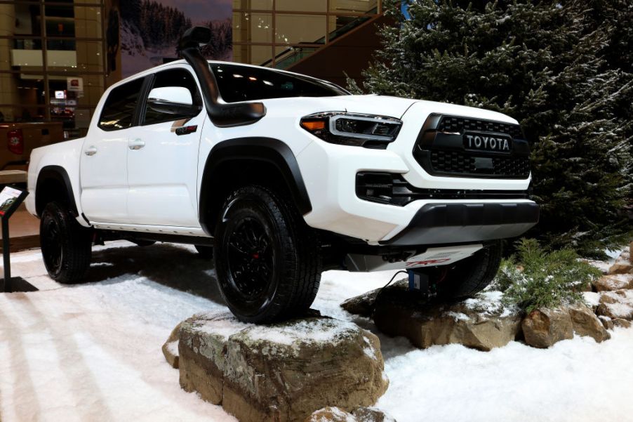 A white 2020 Toyota Tacoma on display at an auto show.