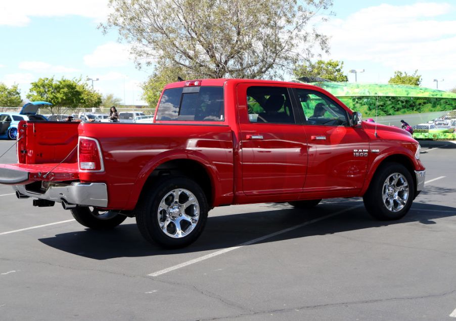 A red Dodge Ram in a parking lot with the tailgate dropped.