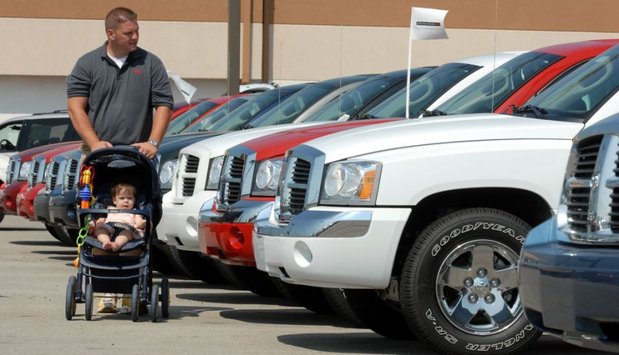 James Stout pushes his 10-month-old daughter Allison in a stroller as he shops for a Dodge Dakota in 2006