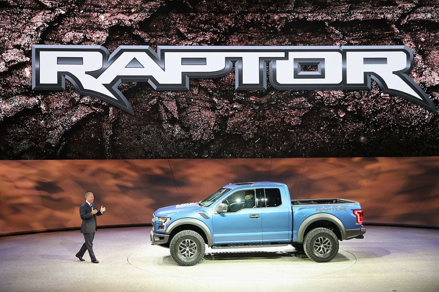 A spokesman showing a Ford Raptor on stage at an event.