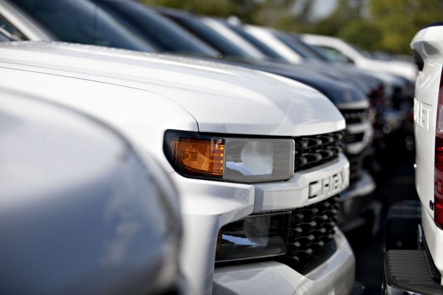 GM Chevrolet Silverado trucks are displayed at a car dealership