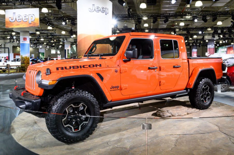 An orange Jeep Gladiator on display at an auto show.