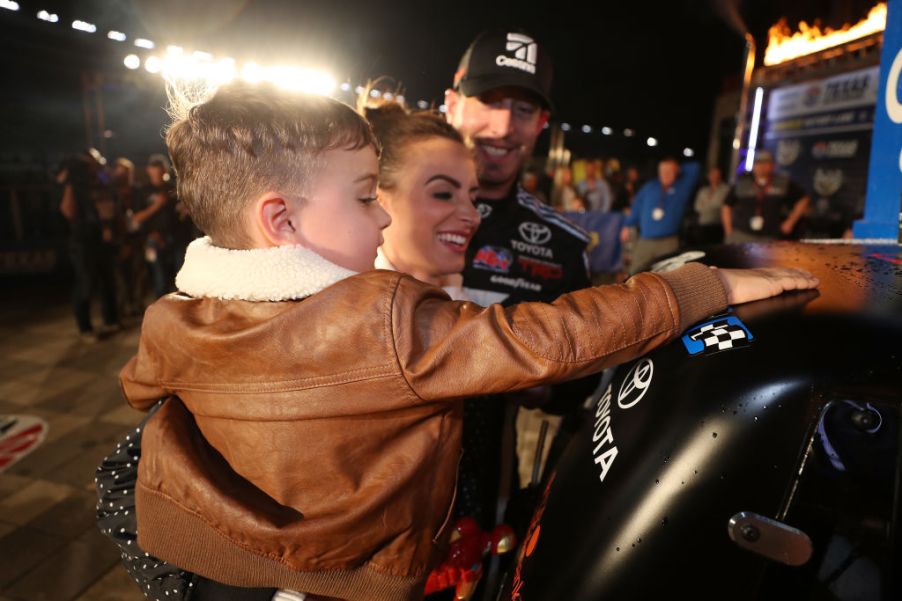 Kyle Busch, driver of the #51 Cessna Toyota, celebrates with his son Brexton and his wife Samantha by placing the Winner's sticker on his ca