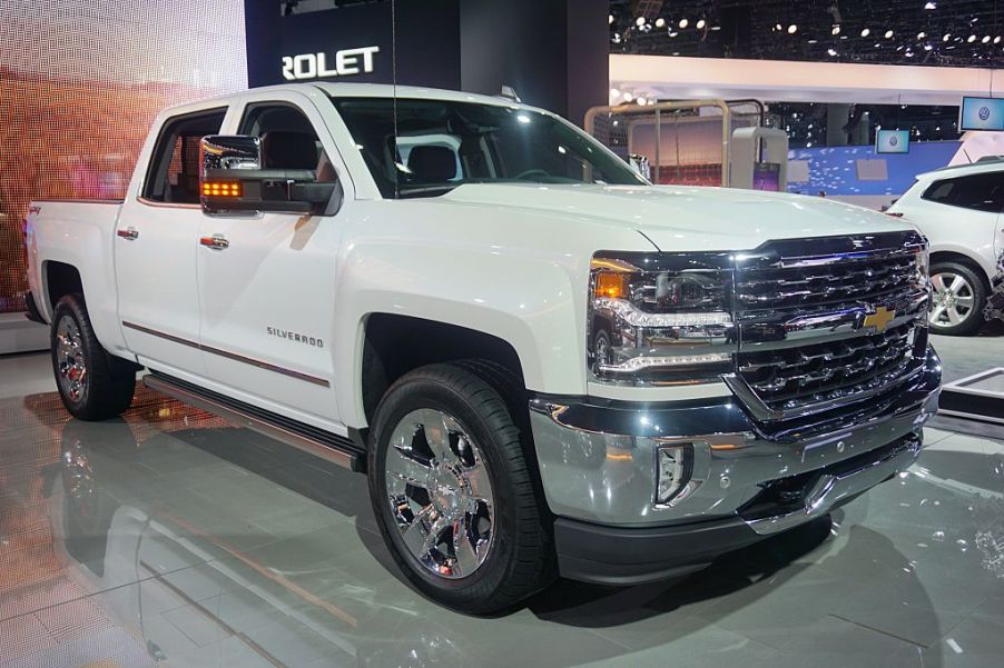 A white Chevy Silverado on display at an auto show.