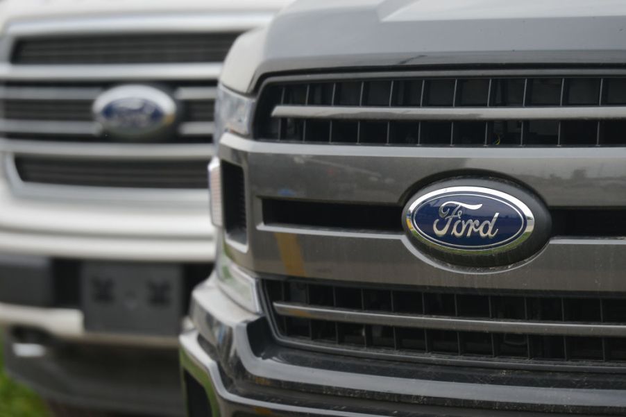 Two Ford trucks on display at an dealership.