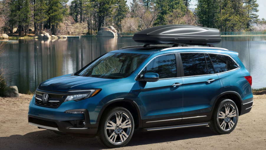 An electric blue 2020 Honda Pilot parked by a lake.