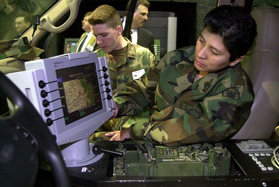 A soldier reading a GPS inside of a Ford military truck