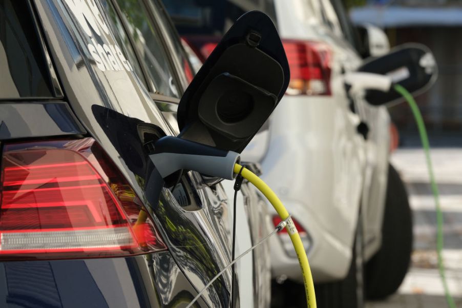 Electric cars plugged into charging stations