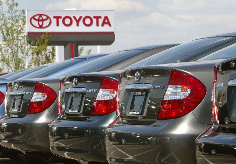 Toyota cars lined up in a dealership's parking low