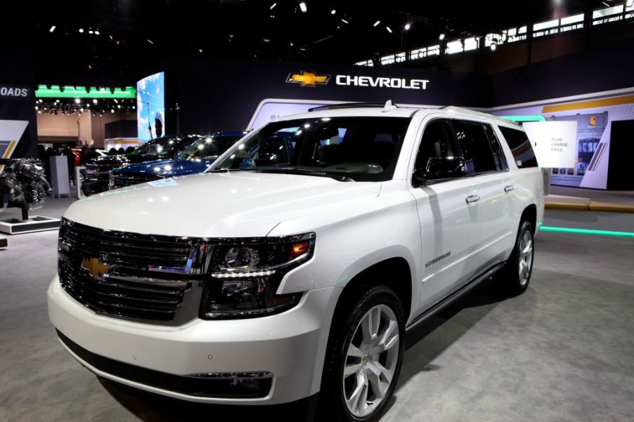 A white Chevy Suburban on display at an auto show