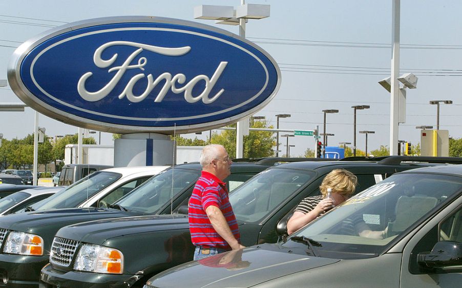 A pair of shoppers looking at new cars