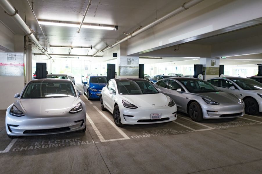 Tesla model 3 cars charging in a parking garage