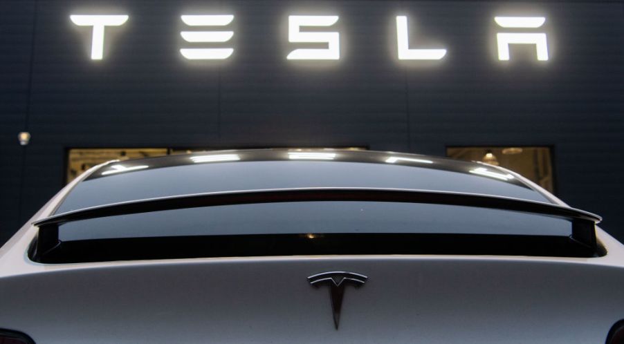 A Tesla Model X stands in front of a sales shop and service center of the manufacturer of electric vehicles, Tesla