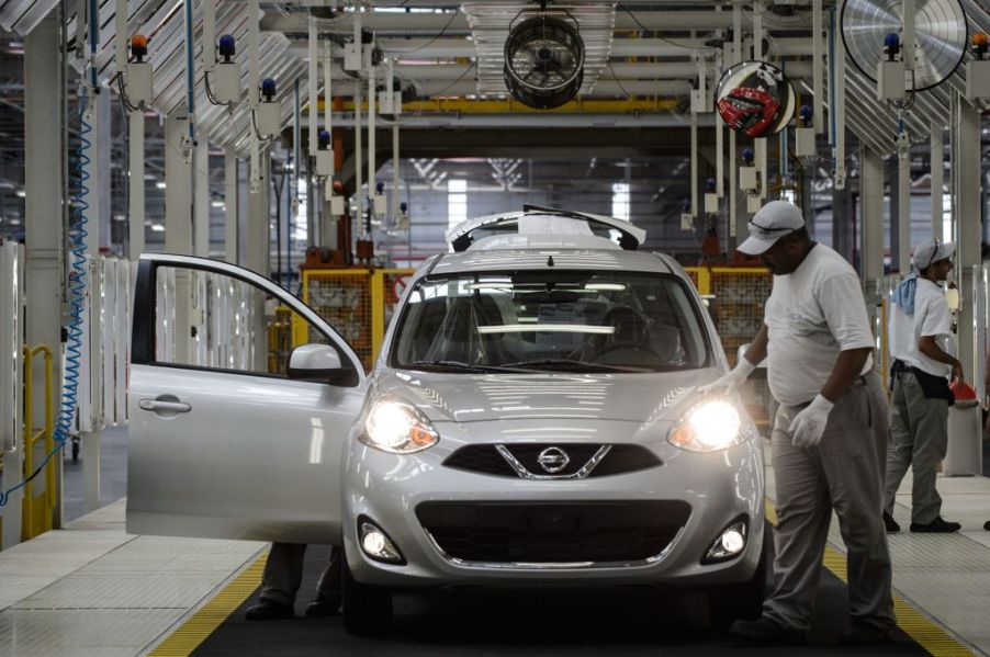 Workers assemble a Nissan Versa in a factory