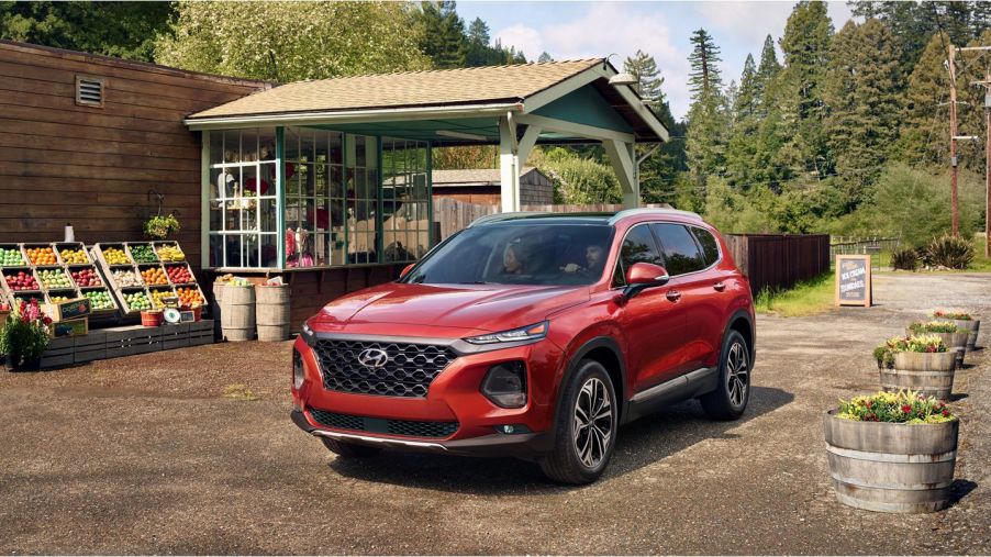 A red 2020 Hyundai Santa Fe parked to near a beach shack.