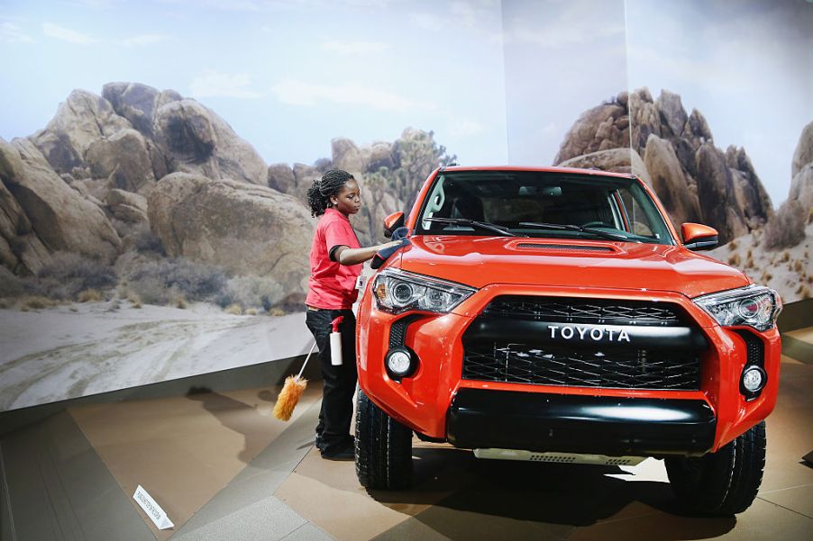 Knatasia Calhoun dusts off a Toyota 4Runner TRD Pro during the media preview at the North American International Auto Show (NAIAS)