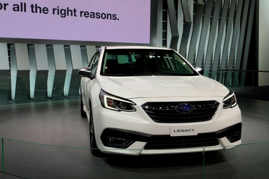 A white Subaru Legacy on display at an auto show