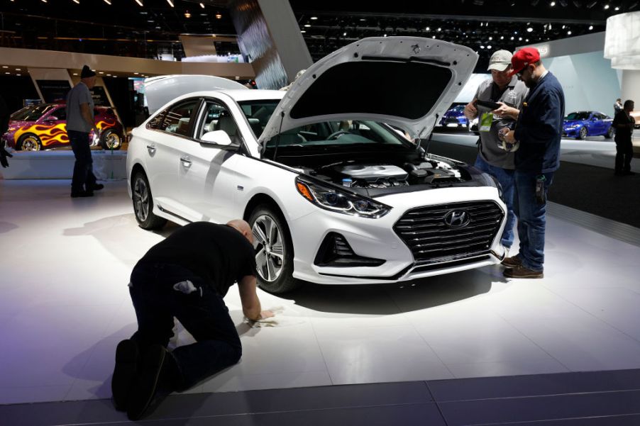 Workers prep around a Hyundai Sonata at the Hyundai 1272exhibit is shown at the 2018 North American International Auto Show