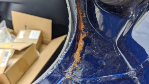 Blue Tesla Model Y's rear hatch, showing rust