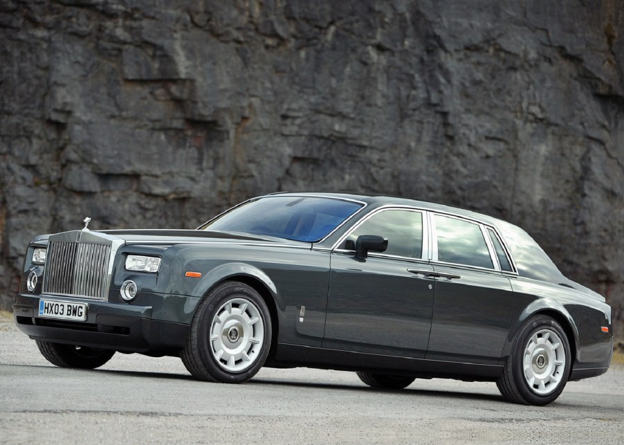 Gray 2003 Rolls-Royce Phantom VII side view, in front of a rocky cliff