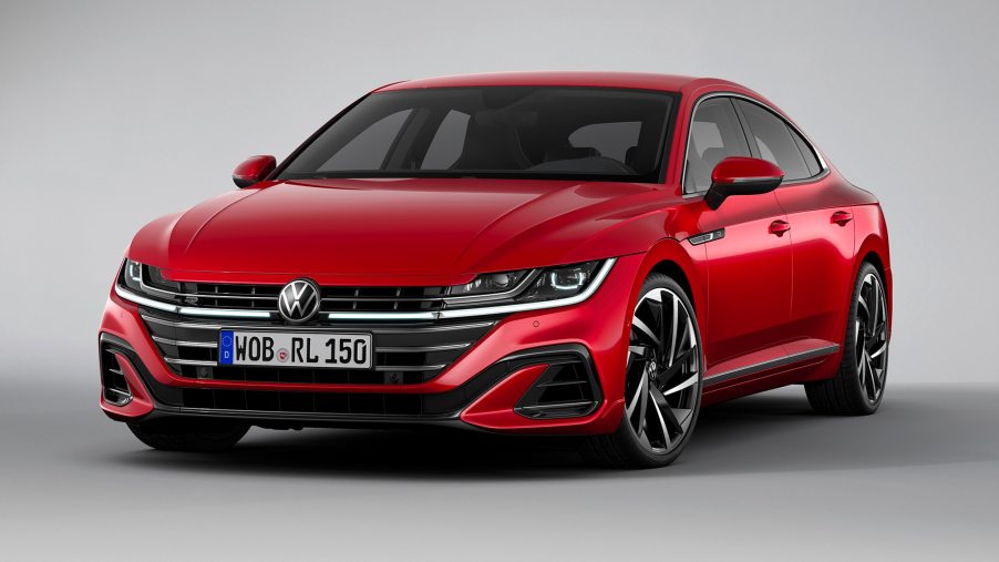 A fierce-looking red Arteon sedan in a showroom setting.