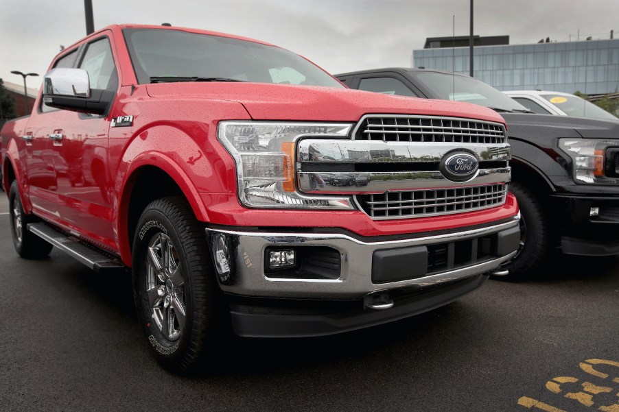 A red Ford F-150 pickup truck offered for sale at a dealership.