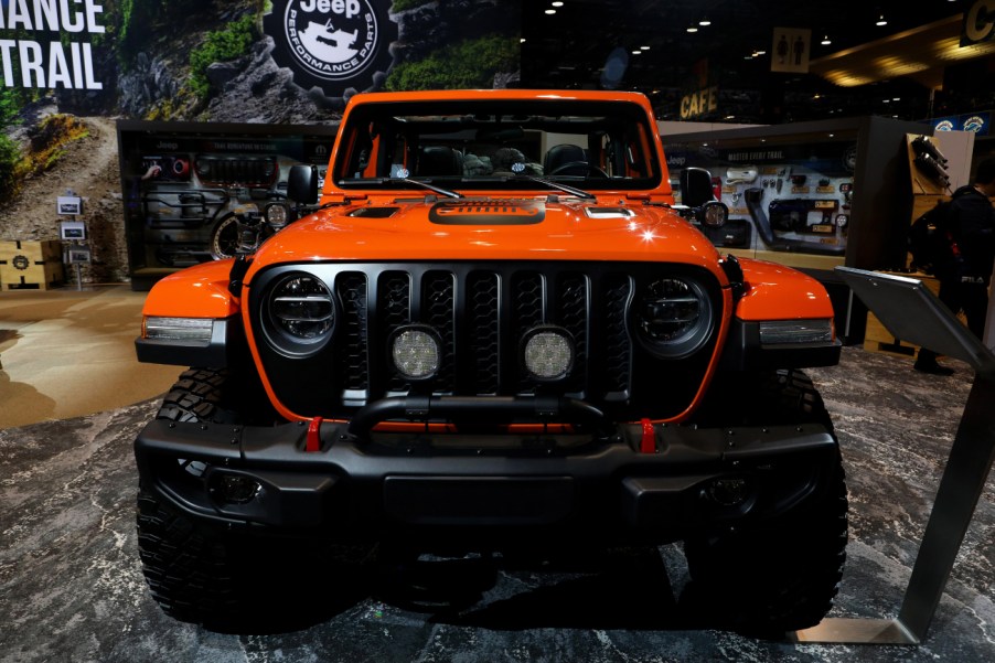 An orange Jeep Gladiator on display at an auto show