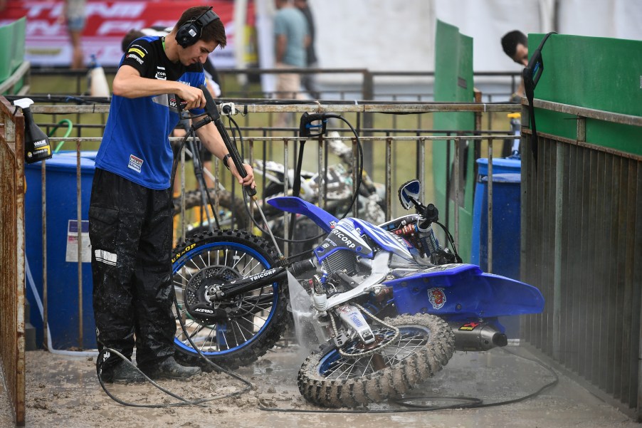 Monster Energy Yamaha Factory MXGP Team crew washes a motorcycle using a pressure washer