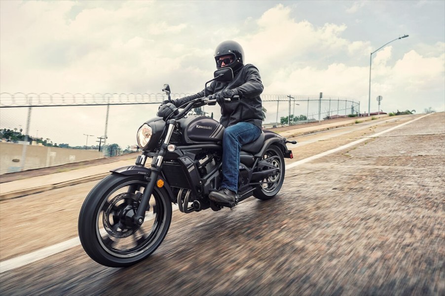 A gray-purple 2020 Kawasaki Vulcan S rides down a wet city street