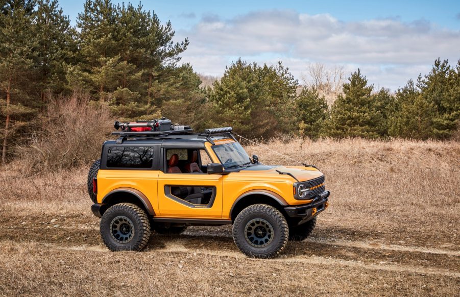 An orange two door 2021 Ford Bronco follows a rutted trail.