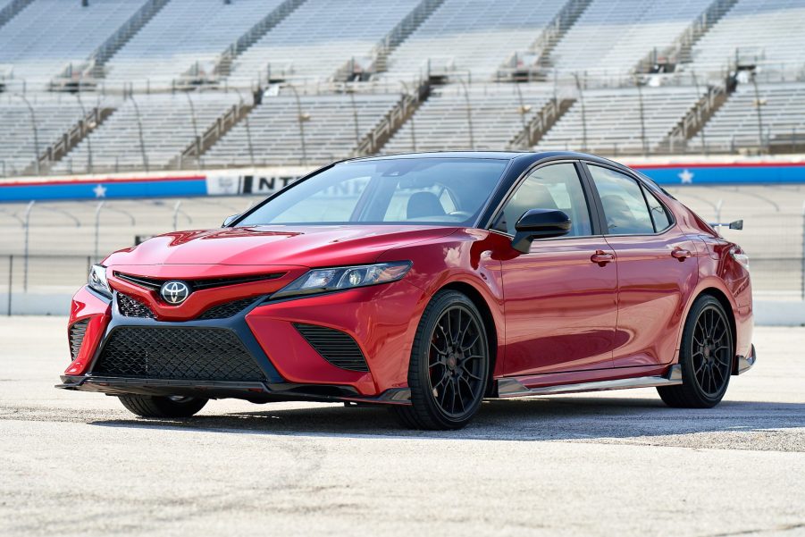 a red Toyota Camry TRD with black exterior detail parked near a race track