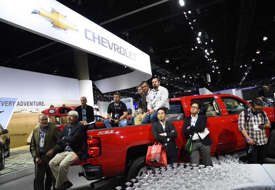 Attendees sit in the bed of a 2015 Silverado 2500 HD as they listen to the Chevrolet press conference, at the Los Angeles Auto Show