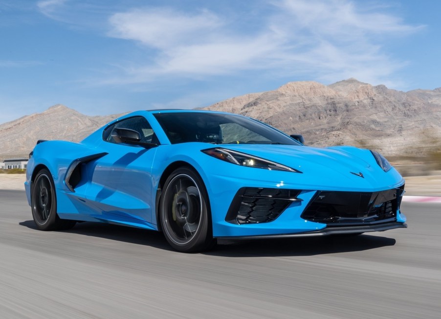 A blue 2020 Chevrolet Corvette C8 Stingray races around a desert racetrack