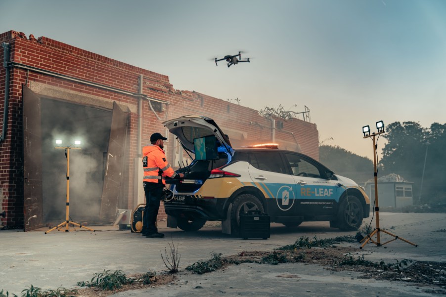 A first responder next to a Nissan Re-Leaf, based on the Nissan Leaf EV, assisting in an emergency response situation.