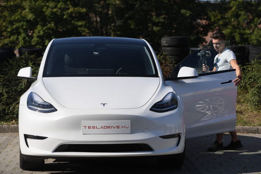 A man films himself looking at a Tesla Model Y