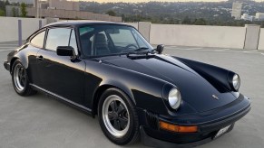 A black 1982 Porsche 911 SC on a parking garage roof