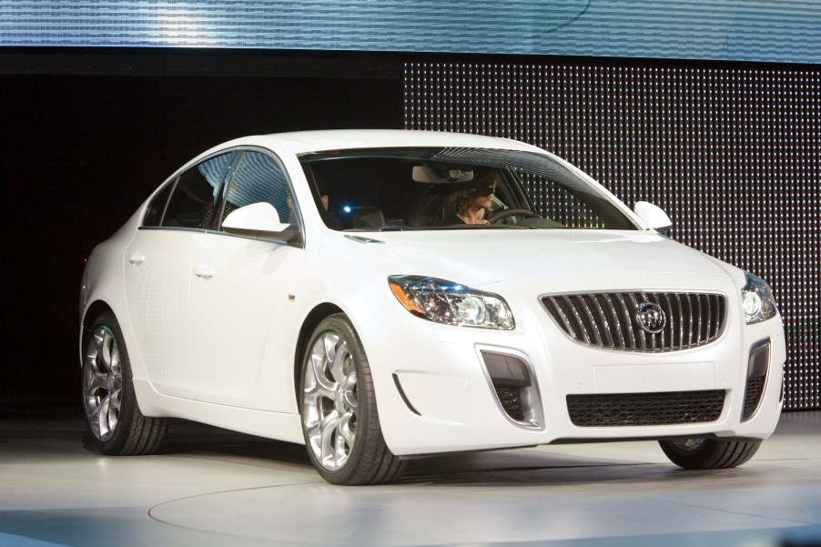 woman drives 2011 Buick Regal on an auto show stage