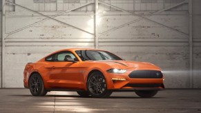 An orange 2020 Ford Mustang EcoBoost High Performance Package in a white-painted warehouse