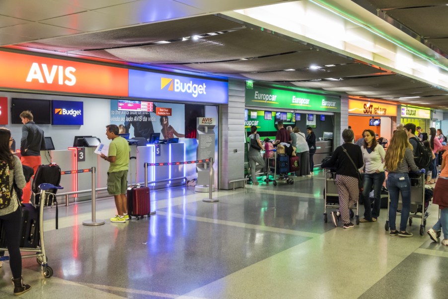 People standing in line to rent a car from car rental agencies like Avis and Budget