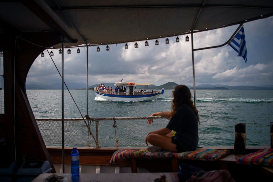 Tourists take part in a dolphin watching tour from a boat in the Amvrakikos gulf