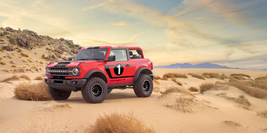 A red 2021 Hennessey Ford Bronco VelociRaptor on display in desert terrain