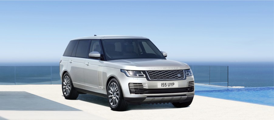 A silver 2021 Range Rover on display with a blue sky background