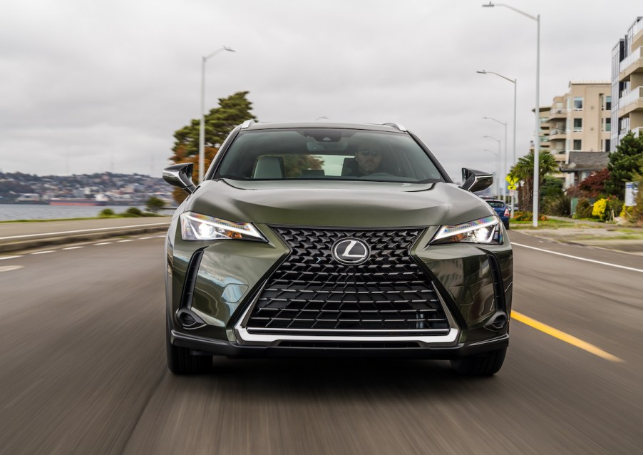 The front of a green 2021 Lexus UX on the road. Many drivers opt to buy a new Lexus because of its luxurious interior.