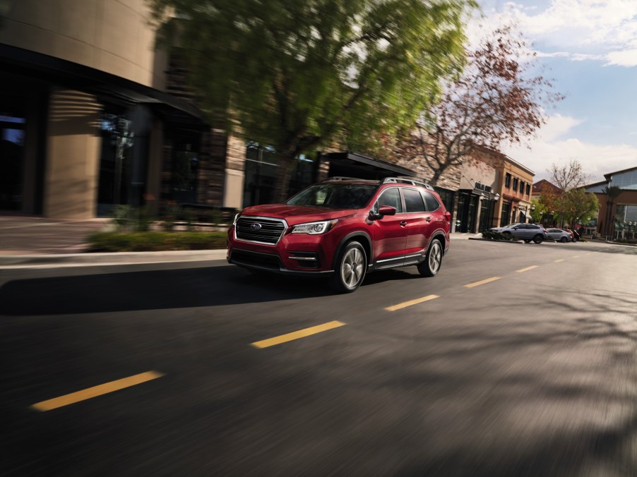 A red 2021 Subaru Ascent driving down a city street