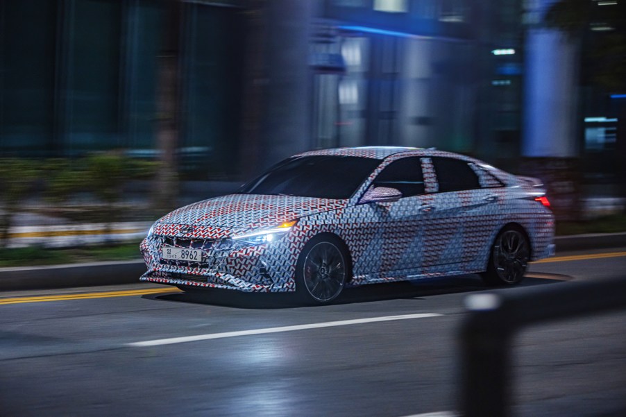 A camouflaged 2021 Hyundai Elantra N driving down a city street