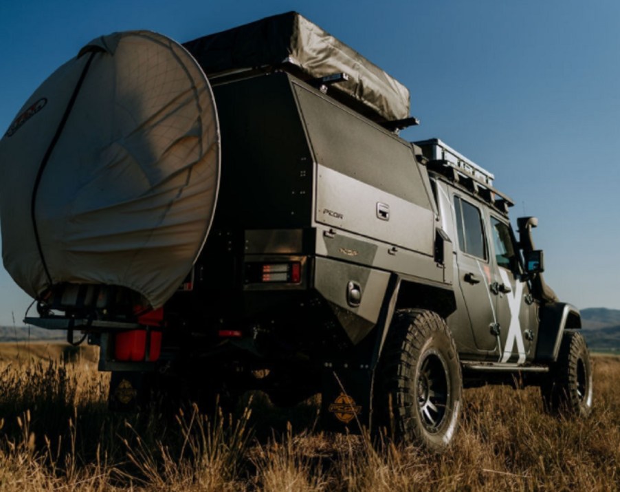 The rear 3/4 view of Expedition Overland's 2019 Jeep Gladiator in a field